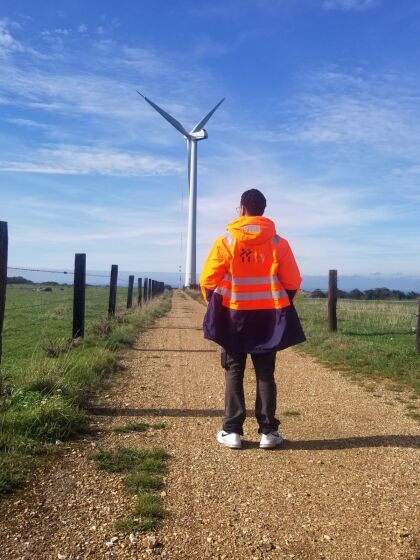 Géomètre devant une éolienne