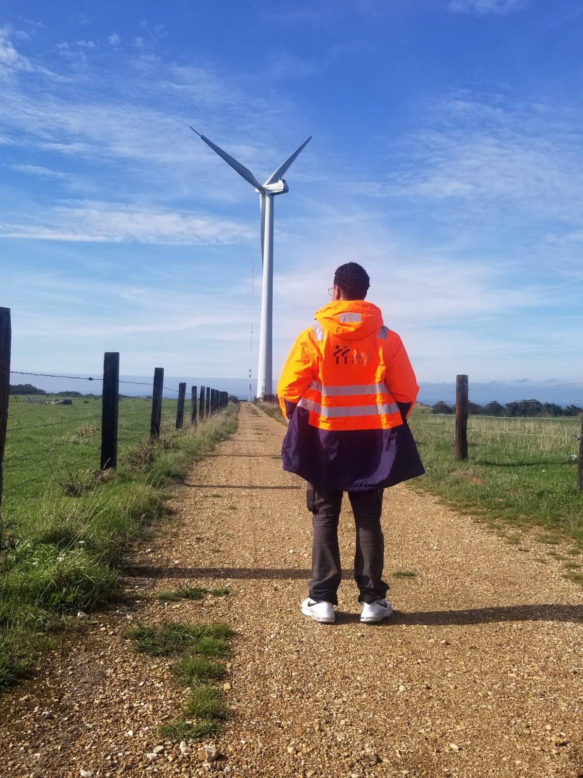 Géomètre devant une éolienne